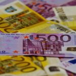 A close-up image of several Euro banknotes arranged in a scattered manner.